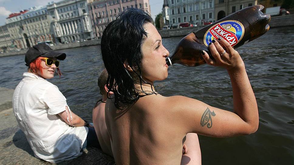 Голая девушка обливает себя пивом на природе фото