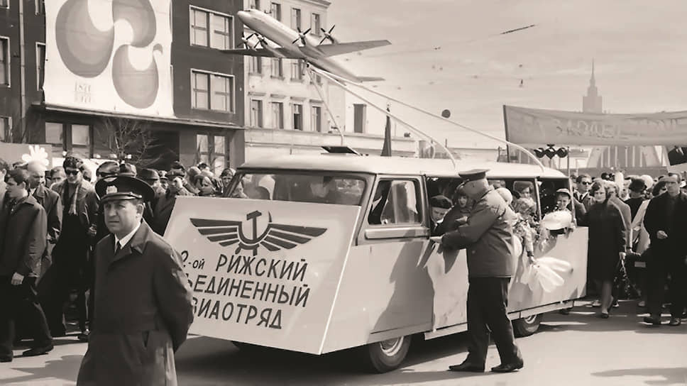 Первомайская демонстрация середины 1970-х на Комсомольской набережной в Риге. Микроавтобус RAF-980 местного производства везет на крыше макет самолета Ил-18, выпускавшегося в Москве