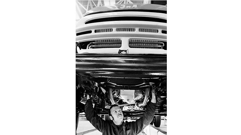 Слесарь-водитель Виктор Лихачев проверяет переднюю подвеску автомобиля «ЗИЛ-130» перед выездом с конвейера. Москва, 1975 год