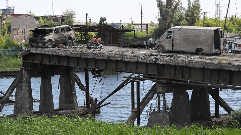 Местные жители ловят рыбу с разрушенного моста в Мариуполе
