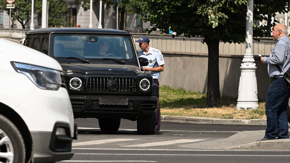 Сотрудник ГИБДД во время общения с водителем автомобиля в Москве