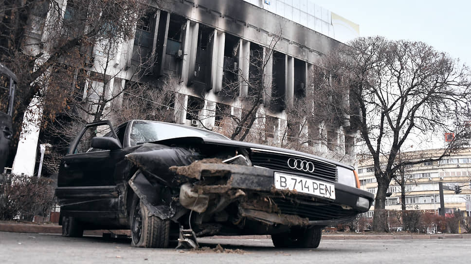 Январь 2022. Последствия массовых акций протеста в Казахстане из-за повышения цен на топливо. Разбитый автомобиль на фоне пострадавшего здания телеканала «Мир»