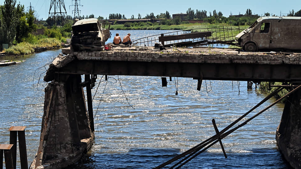 Июль 2022. Рыбаки и машины на разрушенном мосту напротив металлургического комбината «Азовсталь»