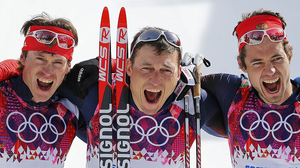 Александр Легков (в центре), олимпийский чемпион, Максим Вылегжанин (слева), серебряный призер, и Илья Черноусов (справа), бронзовый призер в лыжных гонках на дистанции 50 км