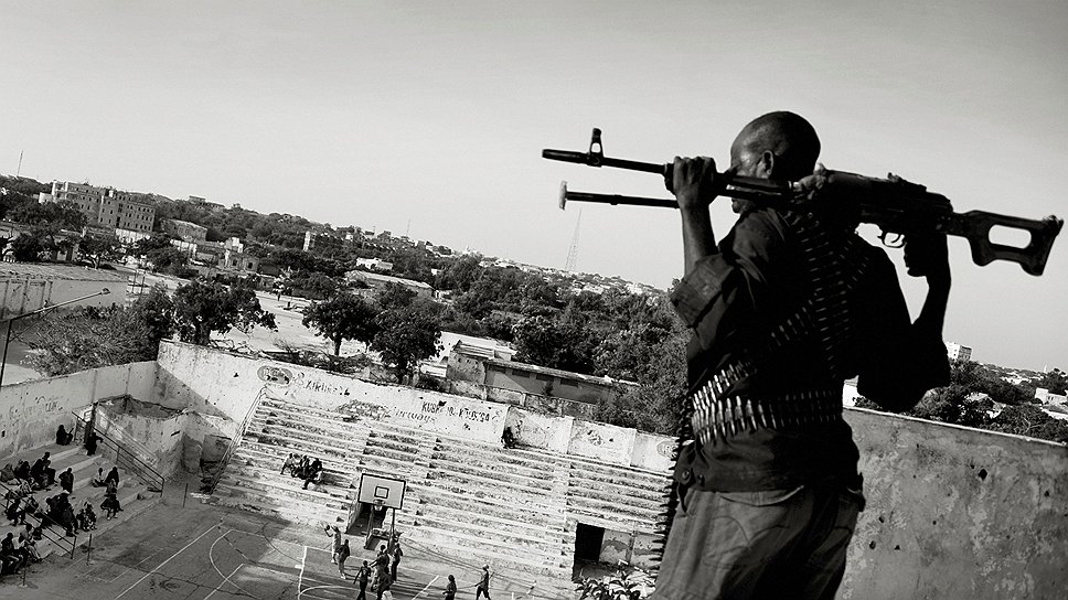 Первый приз в категории &quot;Спорт&quot;. 21 февраля 2012 года. Вооруженный охранник наблюдает за игрой в баскетбол женских команд в Сомали. Автор: Йан Граруп