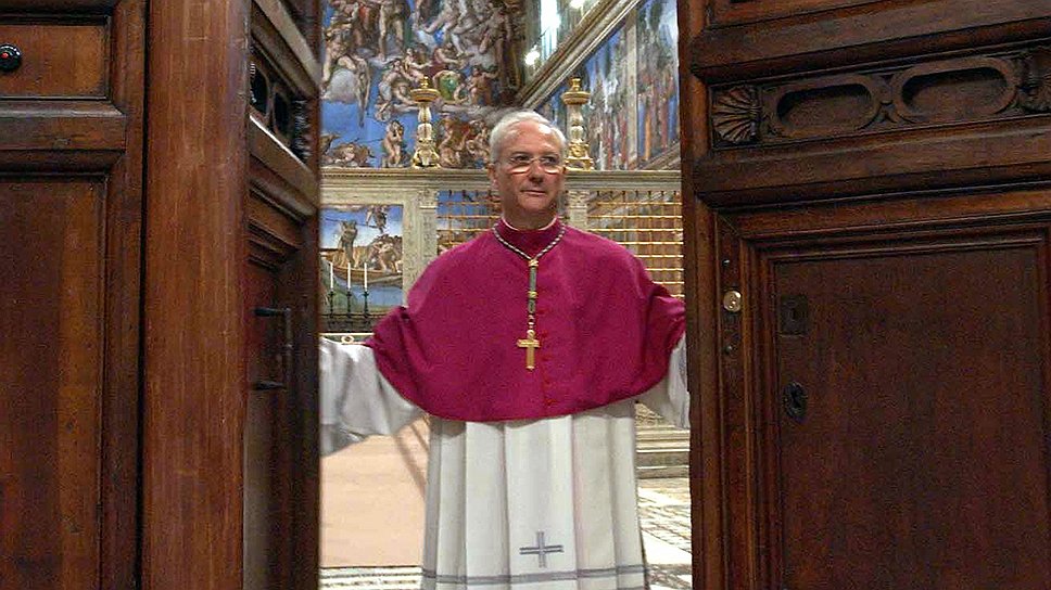 Один из кардиналов открывает двери капеллы после избрания нового духовного лидера 
