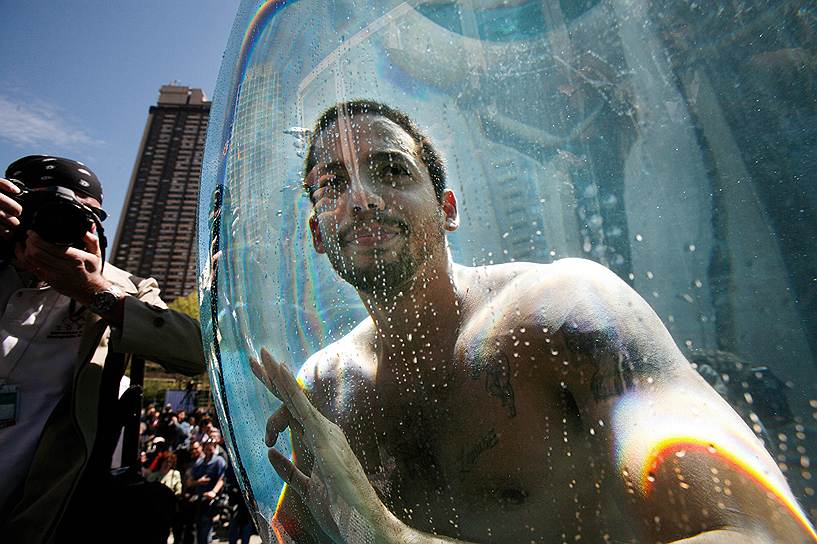 Фокусник Дэвид Блейн передает, что у него все ОК, после погружения на глубину сферы с водой в Линкольн-центре в Нью-Йорке