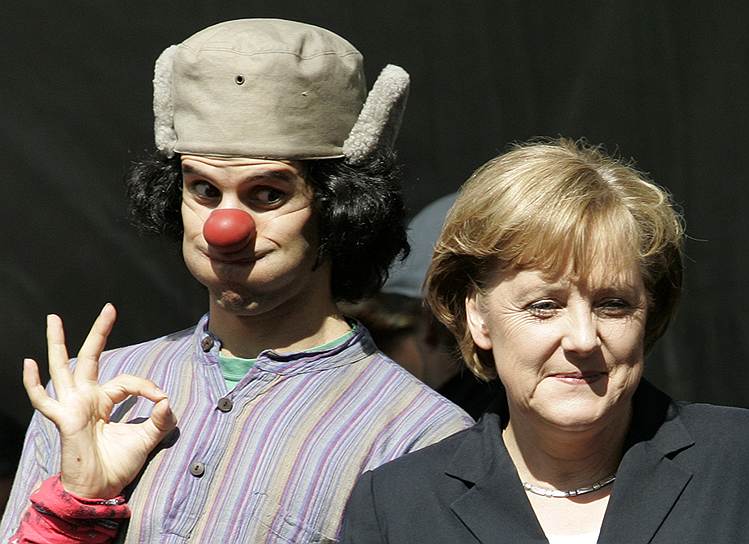 Молодой клоун выступает рядом с канцлером Германии Ангелой Меркель
