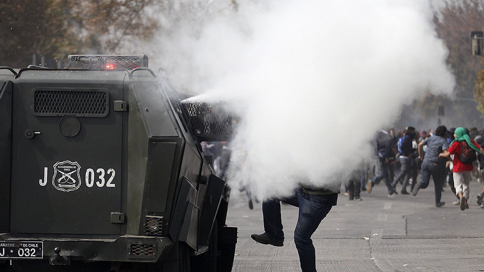 Стражи порядка в Сантьяго применили слезоточивый газ после того, как из толпы демонстрантов полетели камни, а участники акции начали крушить витрины и светофоры.