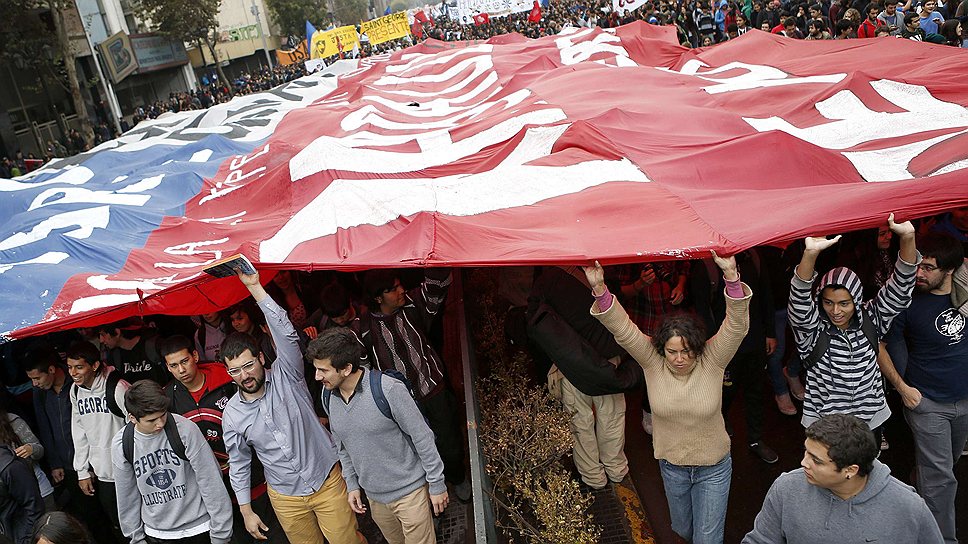 Тысячи участников протестного марша в Сантьяго несли огромный флаг Чили, призывая правительство вспомнить об интересах своих граждан.