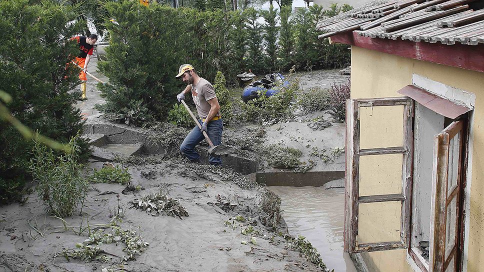 Житель австрийской деревни Эммерсдорф расчищает свой участок от воды и грязи