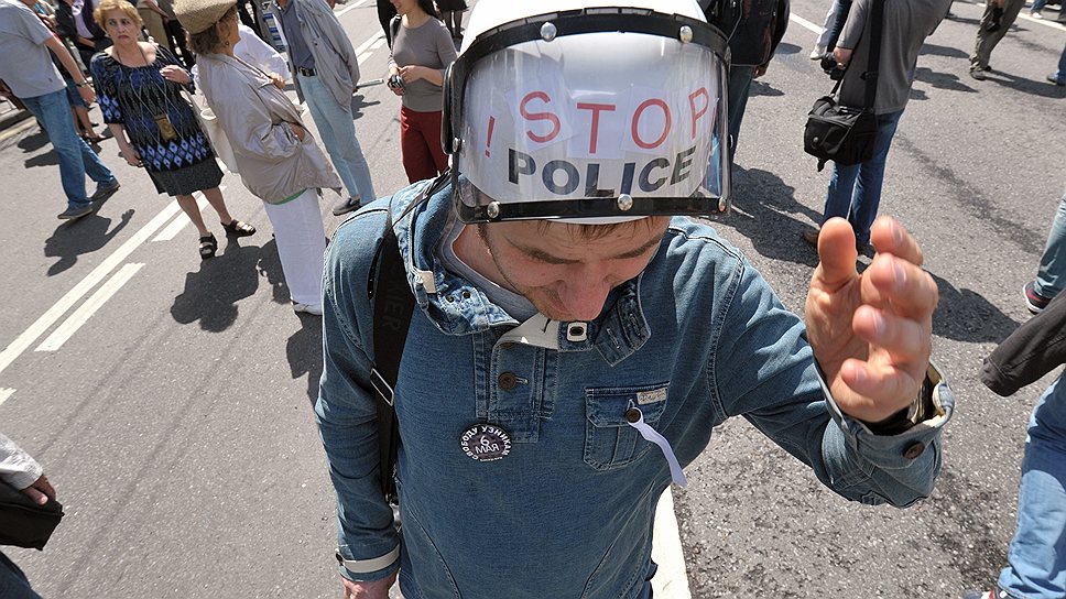 Участник акции с надписью в шлеме на голове «Стоп полиция»