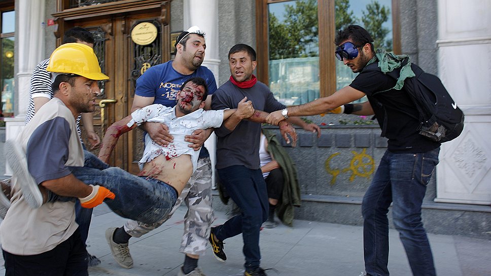 Демонстранты помогают раненному в ходе беспорядков на площади Таксим в Стамбуле