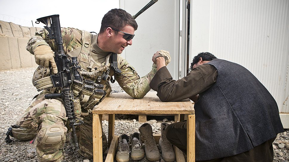 Американский солдат и сотрудник афганской полиции меряются силой в армрестлинге в районе Майванд провинции Кандагар, Афганистан