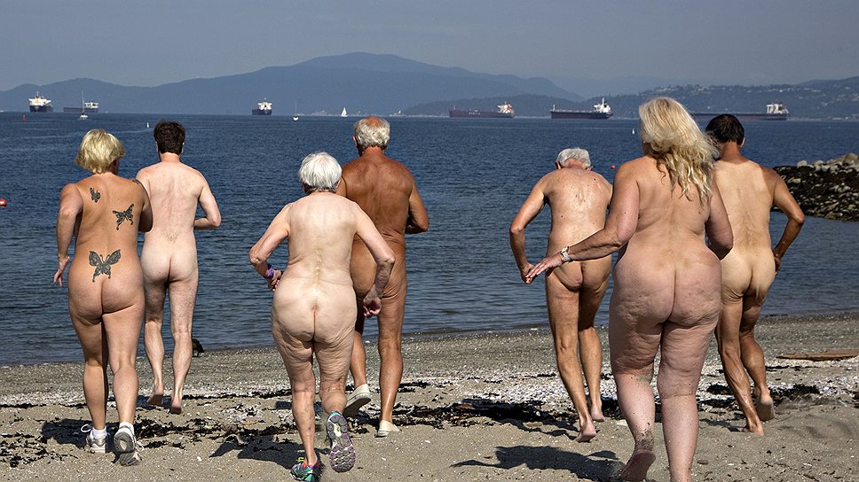 Забег нудистов по мелководью во время фестиваля Bare Buns Run на пляже в Ванкувере