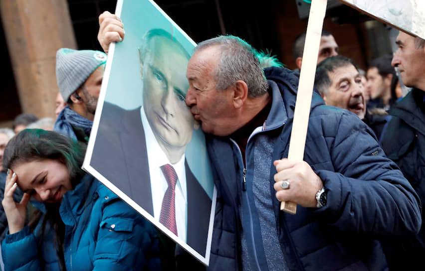 2019 год. Сторонник президента России Владимира Путина целует его портрет на митинге в Белграде 