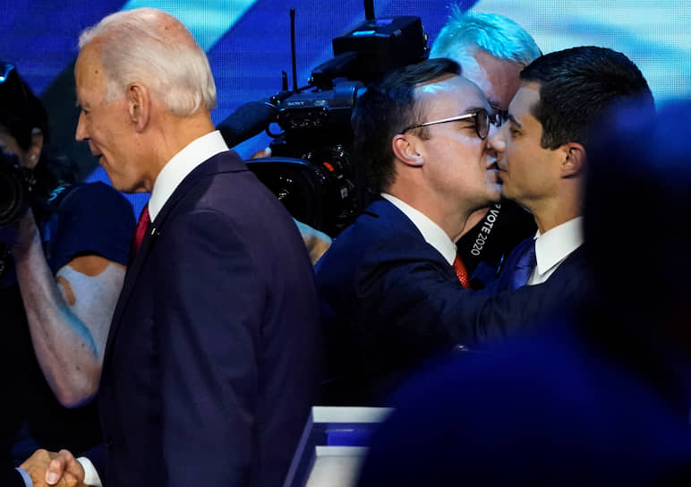 2019 год. Кандидат в президенты США Пит Буттиджич (справа) целует своего мужа Частена Глезмана рядом с другим кандидатом в президенты Джо Байденом (слева) на дебатах в Хьюстоне 