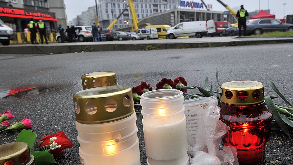 К магазину, точнее, к барьеру полицейского оцепления, жители Риги приносят свечи и цветы — их к вечеру пятницы скопилось огромное количество