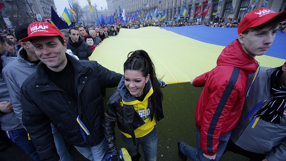 Певица Руслана Лыжичко (в центре) несла украинский флаг во время акции протеста против приостановления евроинтеграции Украины в Киеве