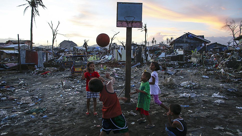 Дети играют в баскетбол на развалинах города