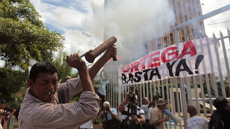 Один из противников правительства президента Даниэля Ортеги стреляет в сторону здания национальной ассамблеи во время акции протеста в Манагуа, Никарагуа