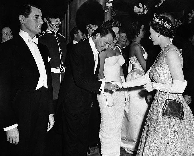 В 1944 году перед концертным залом на Таймс-сквер в Нью-Йорке собрались буквально десятки тысяч поклонниц Ol`Blue Eyes — «голубоглазого Фрэнки». Артист эстрады впервые превзошел по популярности киноактеров
&lt;br>На фото: Фрэнк Синатра и королева Елизавета II