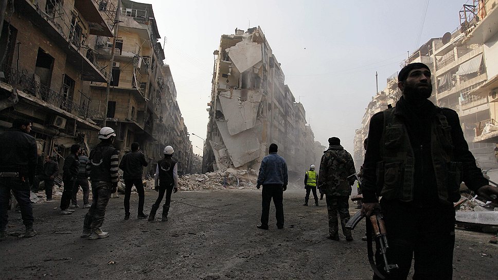Сирийские повстанцы осматривают разрушения после авиаудара по одному из районов Алеппо