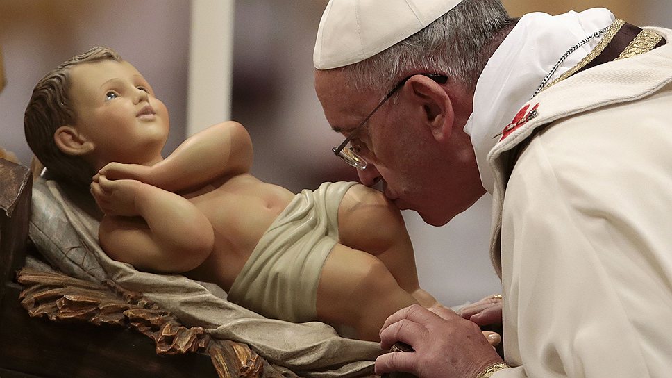 Папа Франциск целует статую младенца Иисуса во время рождественской мессы в Базилике Святого Петра в Ватикане 