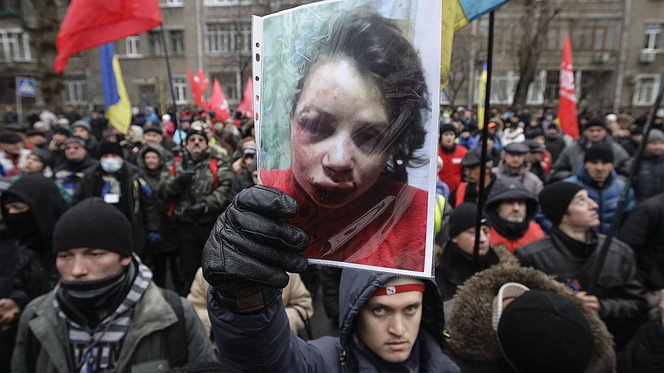 Протестующий в Киеве держит портрет украинской  журналистки Татьяны Черновол, которая была избита спустя час после опубликования статьи 