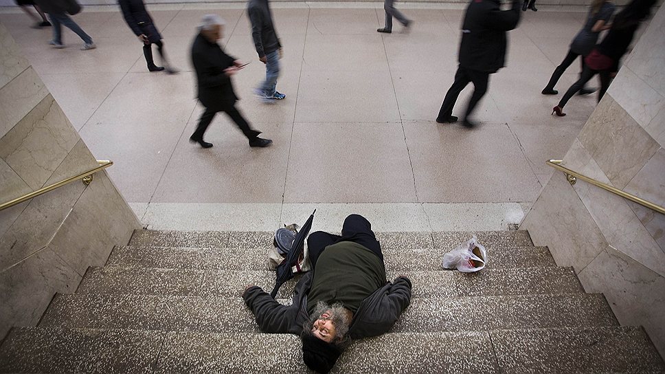 Человек в сочельник спит на лестнице в Нью-Йоркском метро
