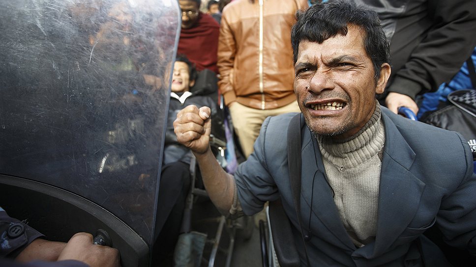 Инвалид пытается прорвать полицейское оцепление во время сидячей забастовки, организованной людьми с ограниченными возможностями в Катманду, Непал 