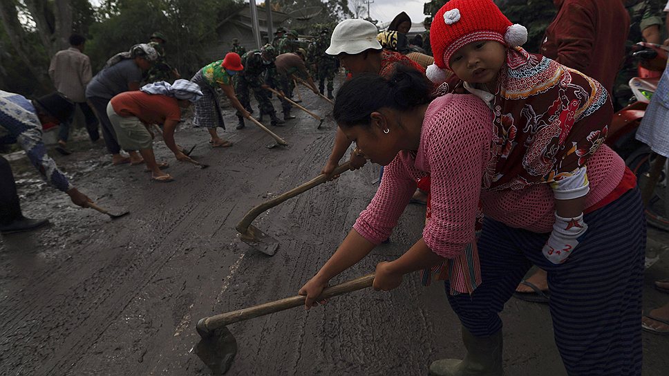 Местные жители убирают пепел, извергнутый вулканом Синабунг на Суматре
