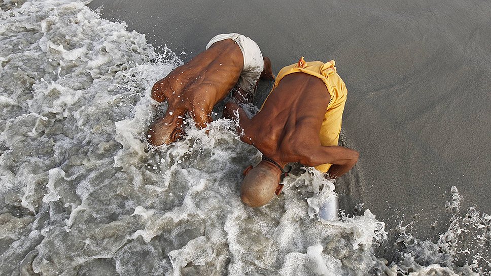 Индийские паломники купаются на месте впадения Ганга в Бенгальский залив