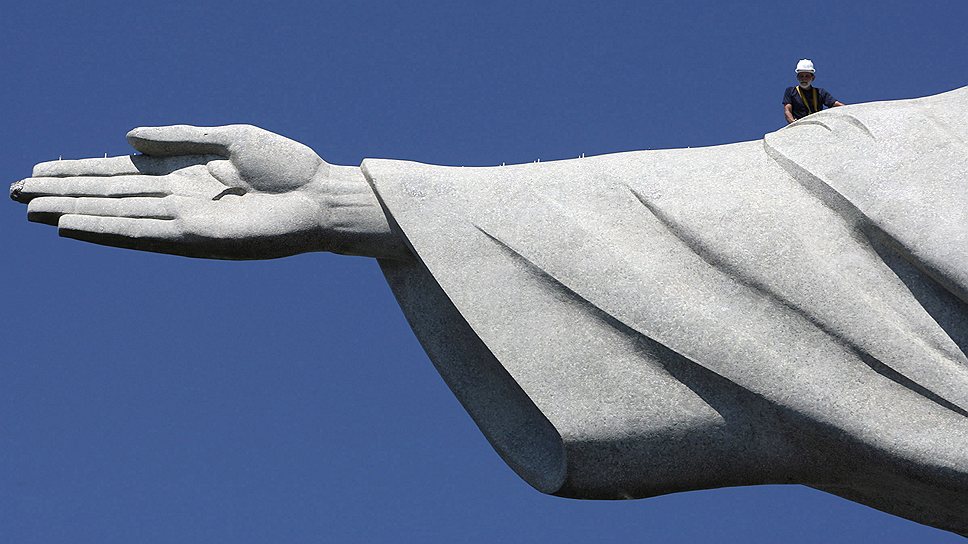 Рабочий исследует повреждения от удара молнии на руке статуи Христа-Искупителя в Рио-де-Жанейро
