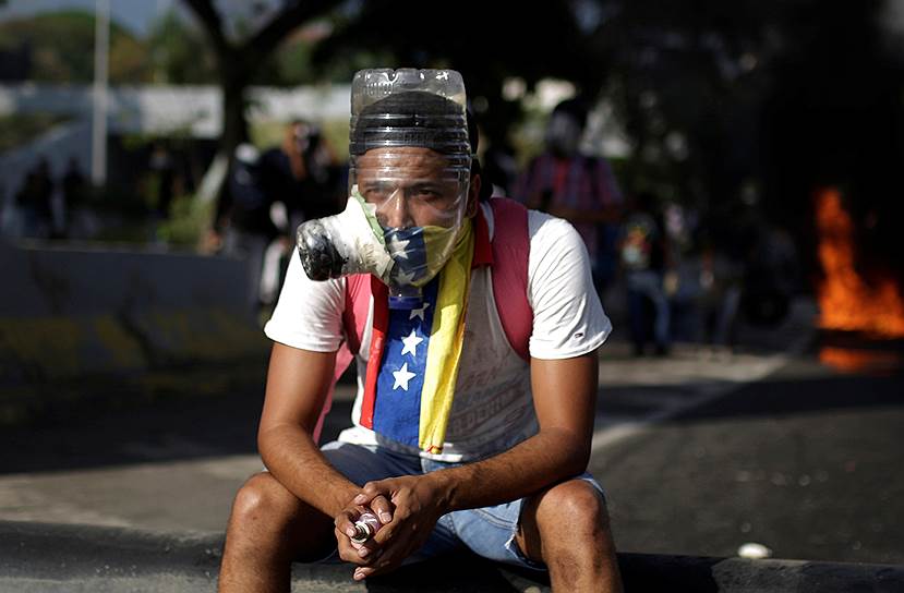2017 год. Антипрезидентские демонстрации в Венесуэле. Участник акции протеста в противогазе из пластиковой бутылки