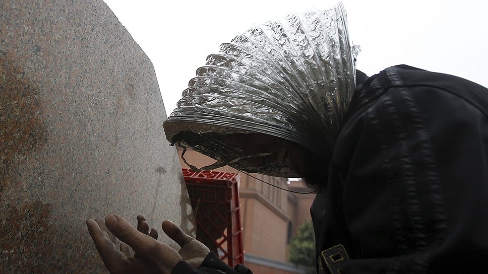 2011 год. Беспорядки в Египте. Протестующий с куском вентиляционной трубы на голове во время молитвы