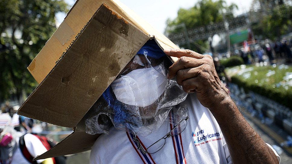 2012 год. Антиправительственные выступления в Таиланде. Протестующий в респираторе и с целофановым пакетом и коробкой на голове