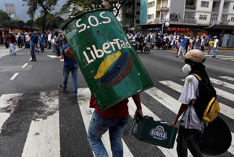 2017 год. «Марш маршей» в Венесуэле. Участник акции с щитом, сделанным из металлической бочки
