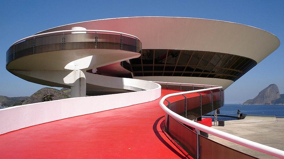 &lt;i>&lt;b>Музей современного искусства/Museu de Arte Contempor&amp;#226;nea de Niter&amp;#243;i&lt;/b> &lt;/i> &lt;br>
&lt;i>&lt;b>Местоположение/год постройки: &lt;/b> &lt;/i> Нитерой, Бразилия/1996 &lt;br>
Этот музей наравне с кафедральным собором в Бразилиа — самое знаменитое творение Оскара Нимейера. «Участок был узким, к тому же окруженным морем, и решение, каким будет музей, пришло очень естественно»,— рассказывал, как родился образ похожего на НЛО музея Оскар Нимейер
