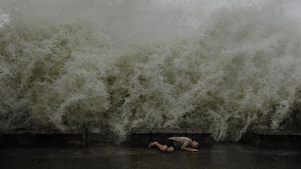 Мальчик прячется от большой волны на набережной в Сочи во время шторма. Автор — Михаил Мордасов, внештатный фотограф ИД «Коммерсантъ»