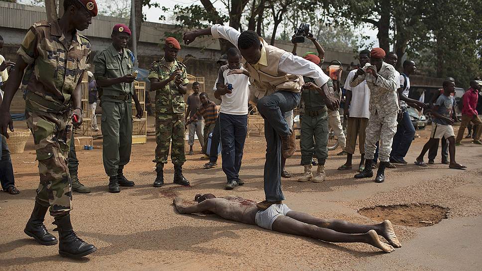 Человек прыгает на трупе мужчины, убитого по подозрению в принадлежности к группировке боевиков Селека в Банги, столице ЦАР