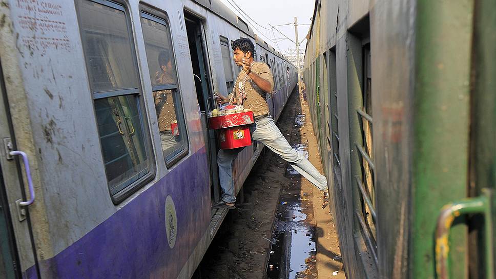 Индийский продавец переходит из одного поезда в другой