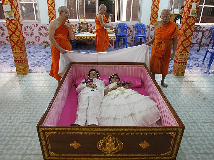 Новобрачные в гробу во время свадебной церемонии, организованной буддистским храмом в день святого Валентина в провинции Нонтабури, Таиланд