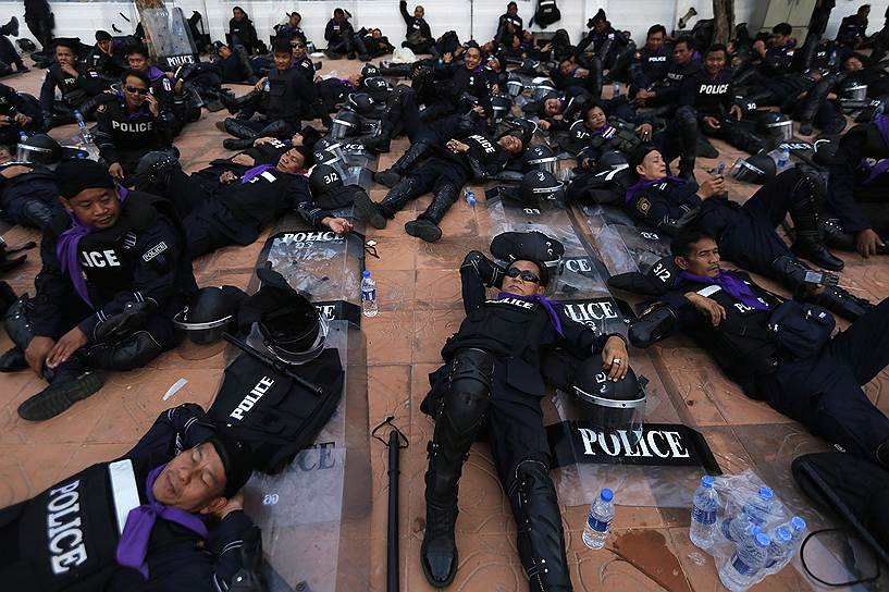 Сотрудники правоохранительных органов отдыхают во время массовых протестов в Бангкоке