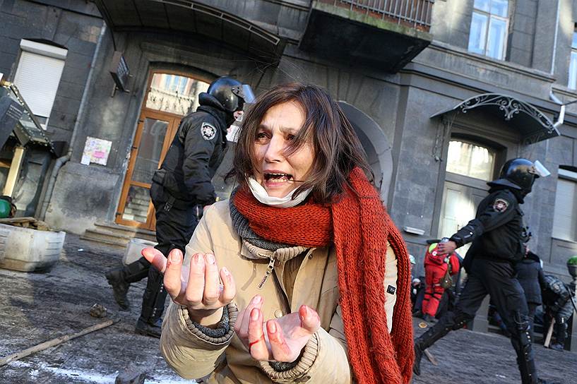 Женщина на Институтской улице в Киеве во время столкновений протестующих с сотрудниками правоохранительных органов