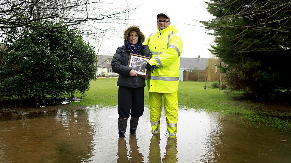 Джейн и Пол Клемент с фотографиями, унесенными из практически затопленного дома