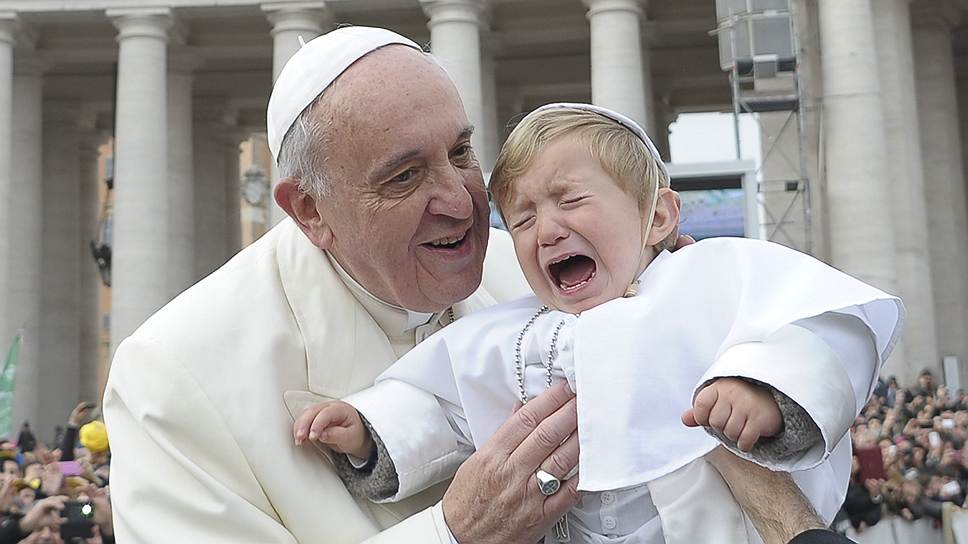 Папа римский Франциск благословляет ребенка во время еженедельной общей аудиенции в Ватикане