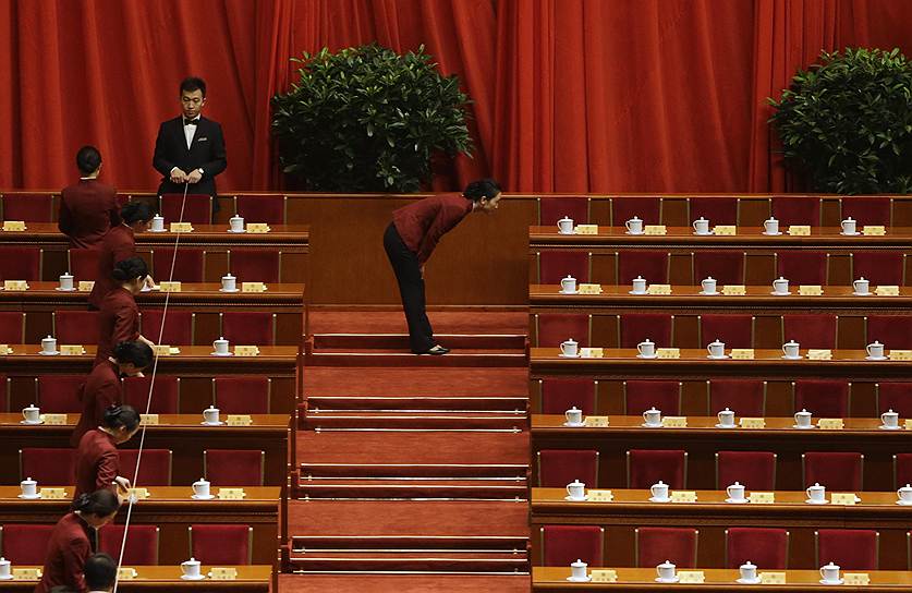 Служащие выравнивают чашки чая перед началом заседания Народного политического консультативного совета Китая в Доме народных собраний в Пекине