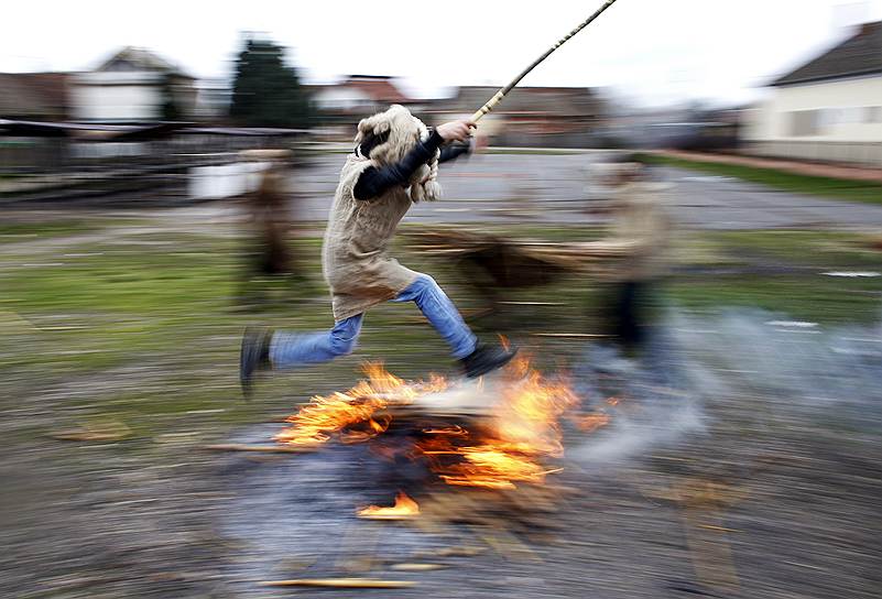 Мальчик прыгает через костер во время сербской масленицы — праздника &quot;Беле Покладе&quot; в деревне Лозовик под Белградом