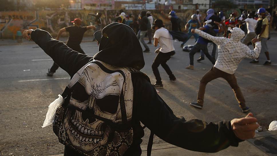 Антиправительственные демонстранты кидают камни в сотрудников полиции в центре Каракаса